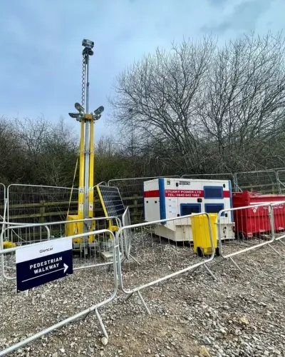 Blog Tall CCTV Tower behind temporary fencing on a site